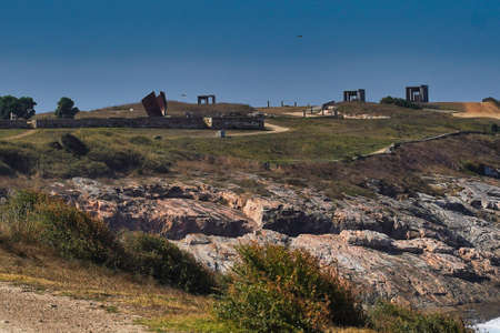 A beautiful shot of a grassy field with buildings in the distance under a blue sky in Coruna, Spainの写真素材
