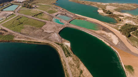 An aerial shot of a landscape surrounded by mountains and lakes with industrial disasterの写真素材