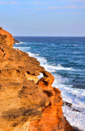 A vertical high angle shot of the rocks on the body of the sea at the Canary Islandsの写真素材