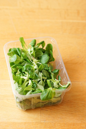 A vertical shot of fresh corn lettuce in a plastic boxの写真素材