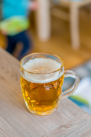 A top view of a glass of beer on a wooden table