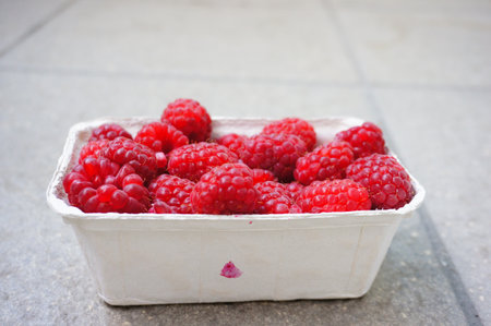 A closeup shot of raspberries in a plastic container