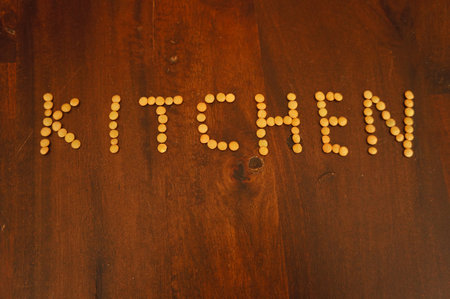 A top view closeup of the word kitchen spelled on the wooden table with lentilsの写真素材
