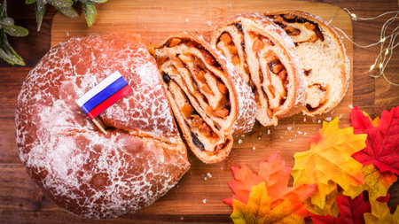 A closeup shot of rolls with fruit fillings, the Russian flag, and autumn leaves on a wooden table