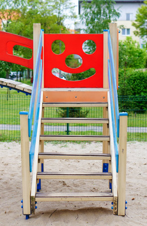 A vertical image of a wooden staircase of a children's playground set with a smiley faceの写真素材