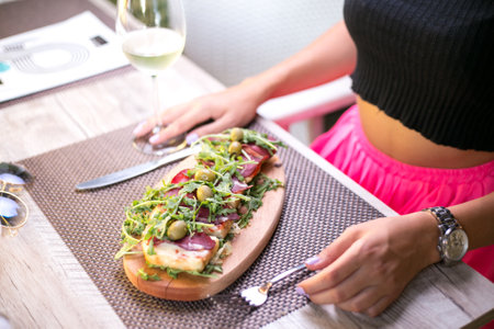 A high angle shot of a woman eating an appetizer plate in a restaurantの写真素材