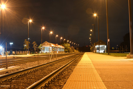The railroads surrounded by lamps and buildings during the nightsのeditorial素材