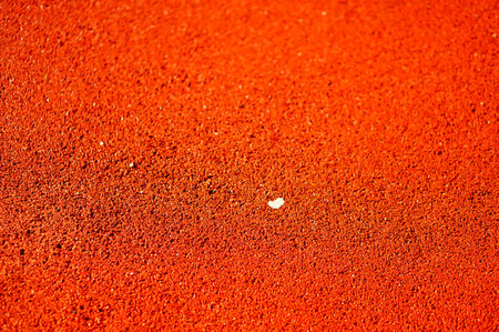 A high angle closeup shot of a red-colored ground outside