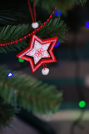 A vertical shot of a multicolor toy hanging on a Christmas tree