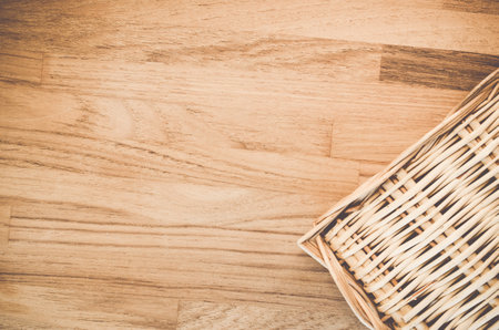 A high angle shot of a woven basket on a wooden surface