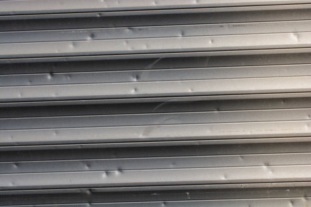 A closeup shot of textured metal shutters with small dentsの写真素材