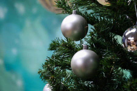 A closeup shot of silver balls hanging on the Christmas tree