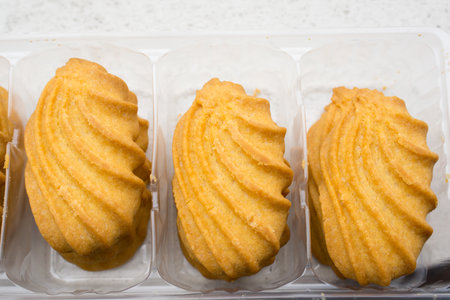 A top view of sweet cookies on a plastic box on a wooden table