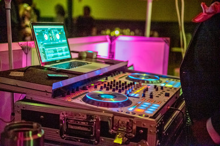 A closeup shot of a DJ set in the dark party hall