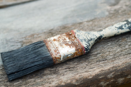 A closeup shot of an old rusted brush on a wooden tableの写真素材
