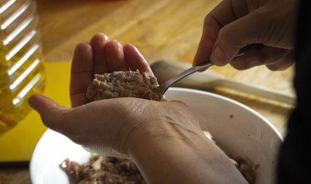 A closeup shot of a female's hands forming meatballsの写真素材