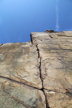 A low angle shot of a wall with a clear blue sky in the backgroundの写真素材