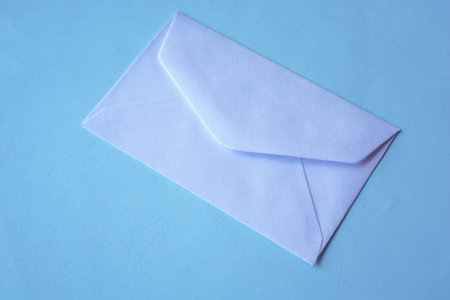 A top view of a white envelope for greeting mockup seasonal concepts on blue backgroundの写真素材