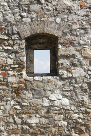 A vertical shot of a window in a building made of stoneの写真素材