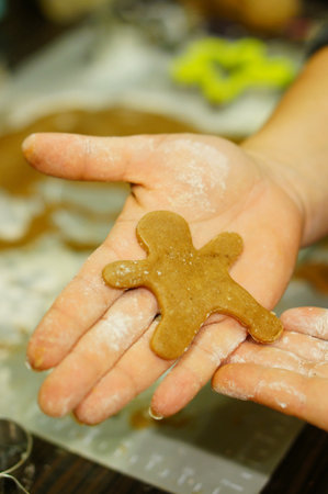A vertical closeup shot of gingerbread in the palm of a personの写真素材