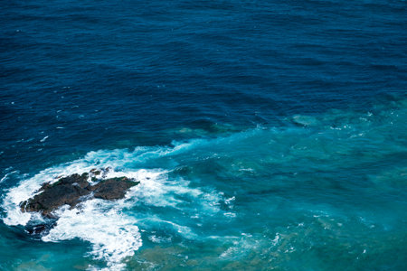 An aerial shot of a wavy sea with two streams crossing at a certain point - perfect for wallpaperの写真素材