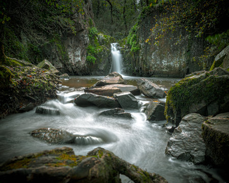 A smooth effect of river waters on background of a waterfall