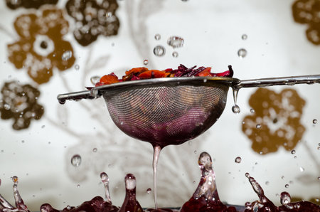 A closeup selective focus shot of the process of making tea with a strainerの写真素材