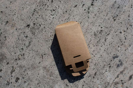 An aerial shot of a thick brown paper bag lying on a concrete floor