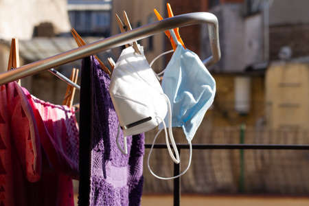 Two COVID-19 masks hanging on the portable drying rack for ventilation and reuse with laundryの写真素材