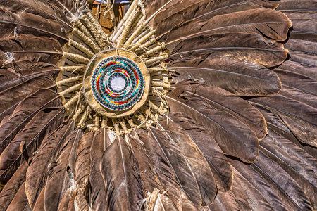 A closeup shot of a traditional decoration with feathers and colorful beads