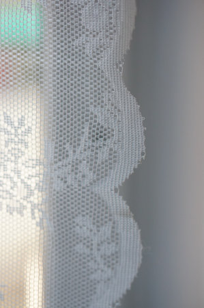 A closeup shot of a white curtain with interesting patterns on a blurred backgroundの写真素材