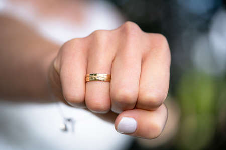 A closeup of the fist of a woman with a wedding ring on her ring fingerの写真素材