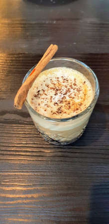 A vertical high angle shot of a coffee in the glass with milk foam on the topの写真素材