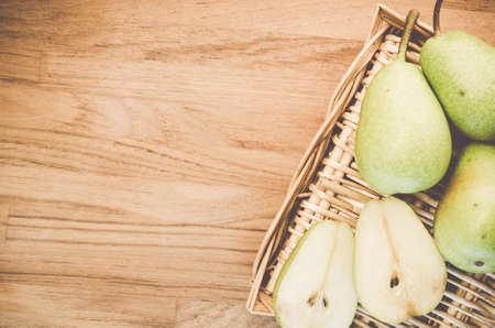 A high angle shot of fresh pears on a wooden surfaceの写真素材