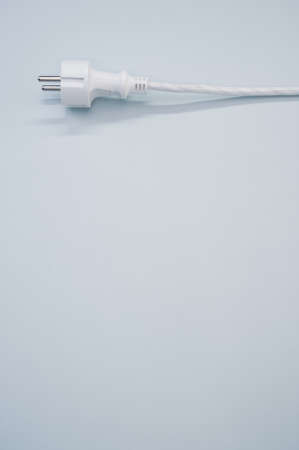 A vertical shot of an electrical plug and wire on a white surfaceの写真素材