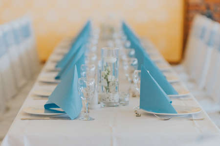 A closeup of a decorated table under the lights in a wedding hallの写真素材