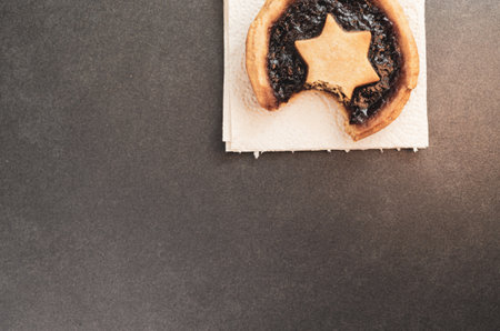 A top view of a delicious little pie with jam on a napkin on a gray surface