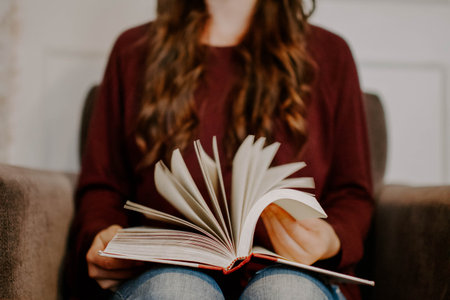 A selective focus shot of a lady holding a bookの写真素材