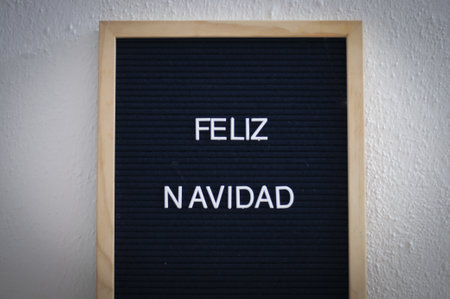 A closeup shot of a Feliz Navidad in a wooden frame displayed on a white wallの写真素材
