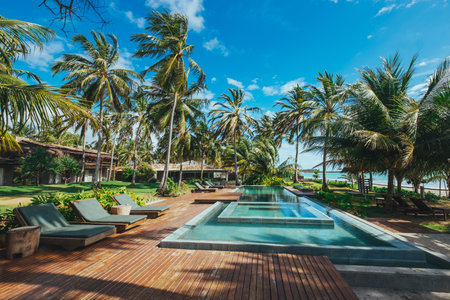 A beautiful shot of a resort with pools and palm trees under a clear skyのeditorial素材