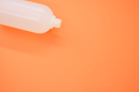 A closeup shot of a plastic bottle on an orange backgroundの写真素材