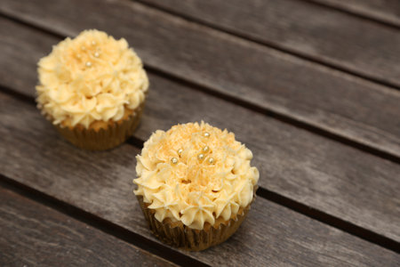 A closeup shot of two cupcakes with yellow cream on topの写真素材
