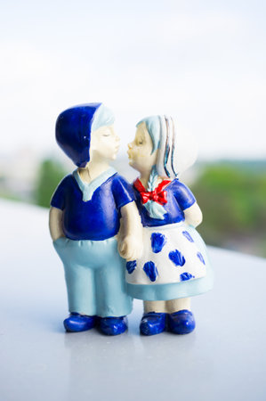 A closeup shot of a cute statue of a boy and a girl holding each other handsの写真素材