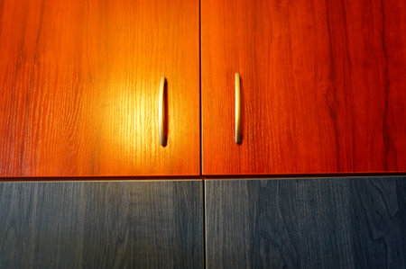 The closeup shot of the shutters of the wooden shelf with metal handlersの写真素材