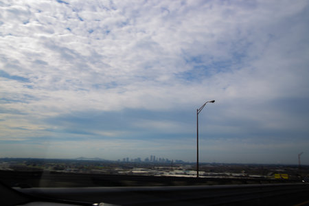 A beautiful cloudy sky over a city as captured from a moving car