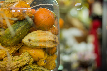 A closeup shot of a variety of colorful gourds and pumpkins in the water in the marketの写真素材