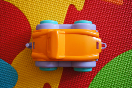 A closeup shot of a small colorful toy car on a puzzle matの写真素材