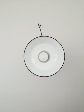 A vertical shot of the lamp hanging from the white ceilingの写真素材