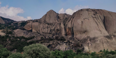 A low angle shot Savandurga Peak Fort against a cloudy blue sky in Savanadurga Indiaの写真素材