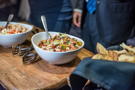 A high angle shot of bowls full of delicious salad on a wooden tableの写真素材